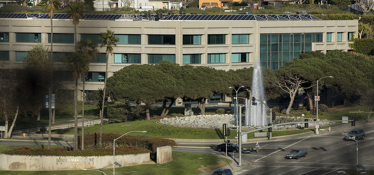 A landscape from the vantage of Lincoln Boulevard, with University Hall, the Lincoln fountain, and the LMU stone wall in frame.